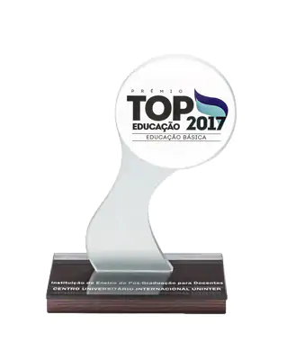 Troféu de vidro ou acrílico transparente, contendo uma placa de reconhecimento, com fundo neutro.